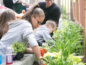 Residents of Jonathan Rose Cos.' Tapestry mixed-income rental in Harlem tend to a community garden as part of an program promoting a healthy lifestyle and a sense of community.