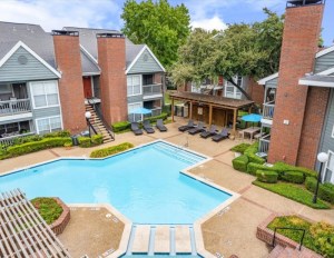 Outdoor pool area surrounded by balconied townhouses