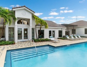 Outdoor pool near two-story apartments and palm trees