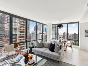 Interior of a living room with windows showing city views