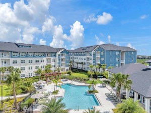 Exterior shot comprising a trio of buildings and a swimming pool inside the Trevesta Place Apartments community.