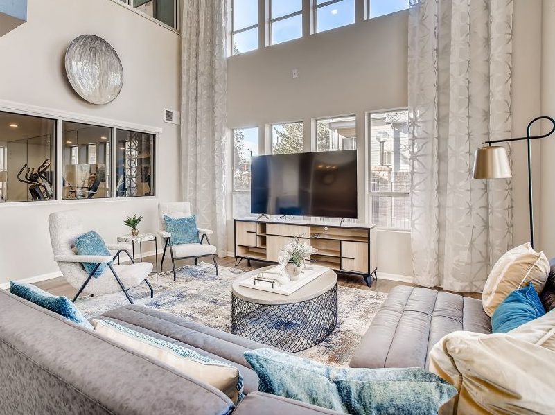Living room at S2's Dartmouth Woods apartments, with off-white walls and furniture and large windows