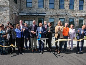 Shot of a group of people celebrating the inauguration of Stone Mill Lofts, an all-electric, 86-unit apartment community in Lawrence, Massachusetts.