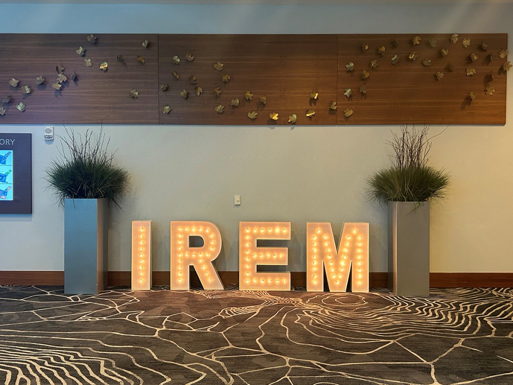 Large, illuminated IREM floor sign against a wall.