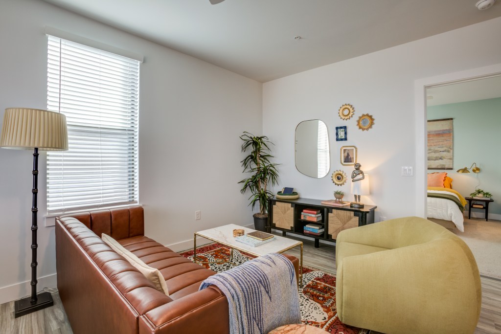 Interior shot of one of the living rooms at Novel Val Vista property in Phoenix. The photo features a leather couch and a chair.