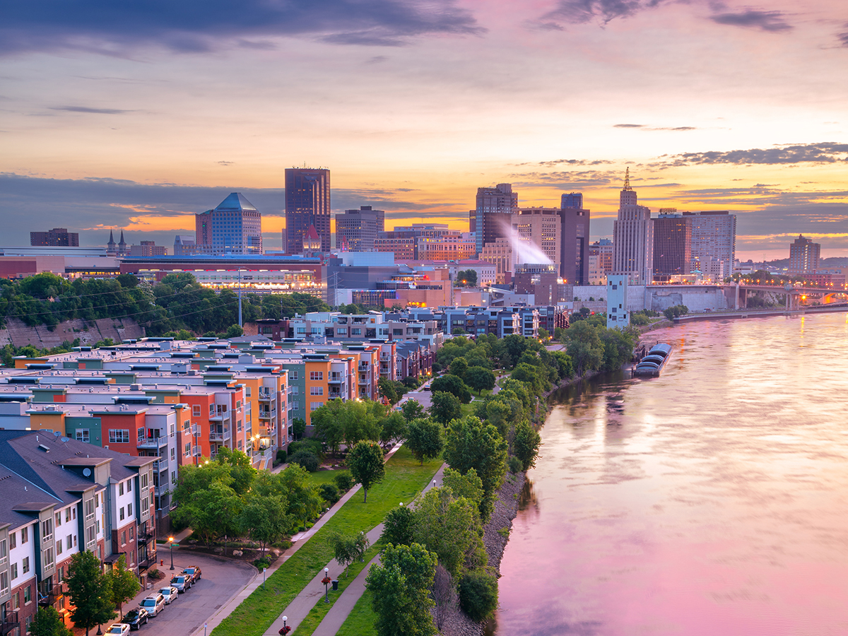 Aerial cityscape image of downtown St. Paul, Minnesota, USA with reflection of the skyline in Mississippi River at beautiful summer sunrise.