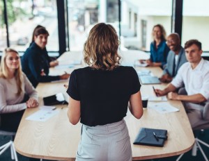 Leader talking to her team at a conference table.