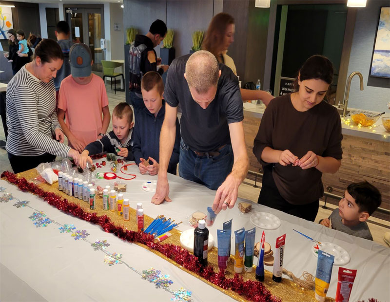 Adult residents and kids decorating holiday ornaments at a Paradigm Management community.