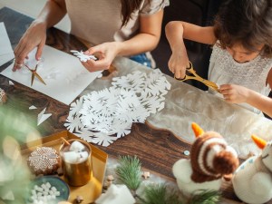 Cutting snowflakes for holiday decorations.