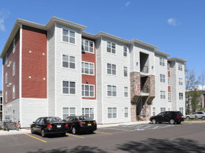 Exterior shot of one of the four-story buildings within Block 20. The mid-rise has a white and brown façade.