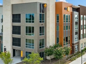 Exterior shot of Northside, a student housing community with a façade in different shades of brown and beige, also showing its logo.
