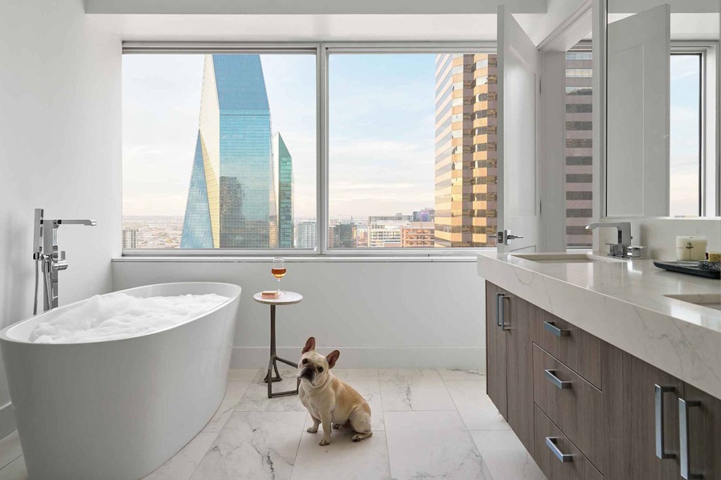 Apartments feature large windows with abundant daylight and city views. Balconies were added to 30 percent of apartments in the all-glass office building. The covered outdoor space is large enough for dining or as an outdoor living room. Image courtesy of Todd Interests