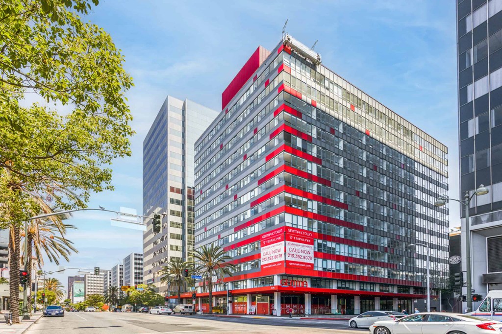 Gemma Apartments is a blend of old and new. The facade kept its mid-century modern character but was visibly enhanced and reskinned with distinct, red panels. Image courtesy of Corbel Architects