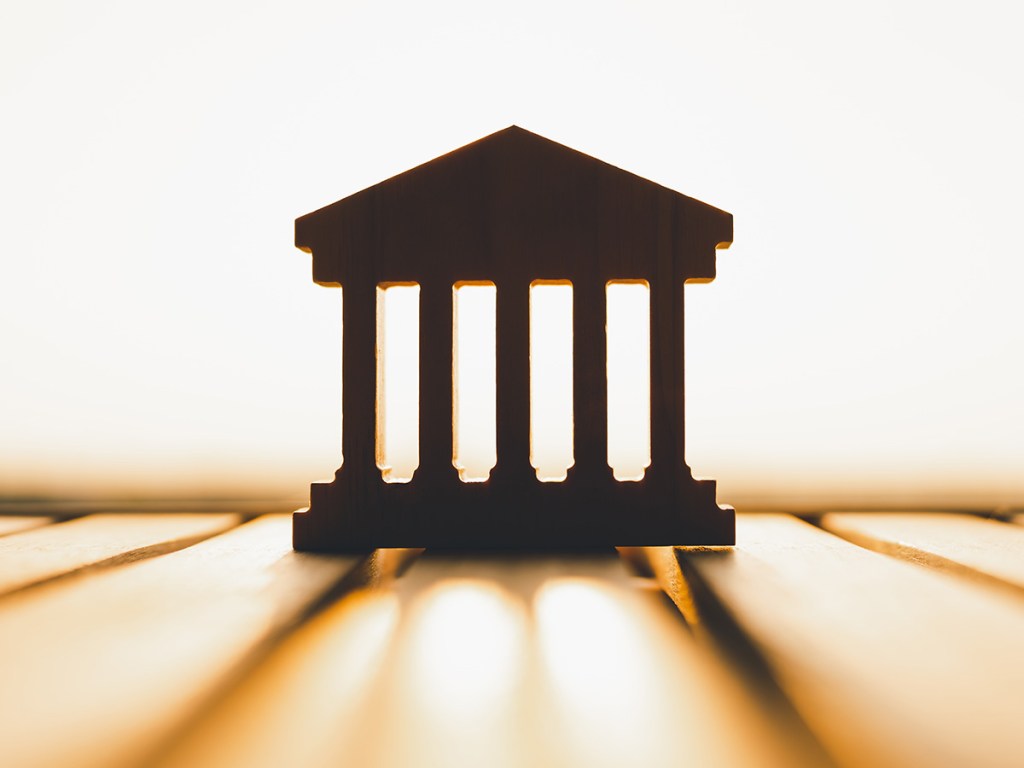 Silhouette of Bank symbol on wood table. Concepts of the banking system, rising interest rates, inflation, deflation, and savings.