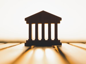Silhouette of Bank symbol on wood table. Concepts of the banking system, rising interest rates, inflation, deflation, and savings.