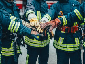 Firefighters with hands stacked.