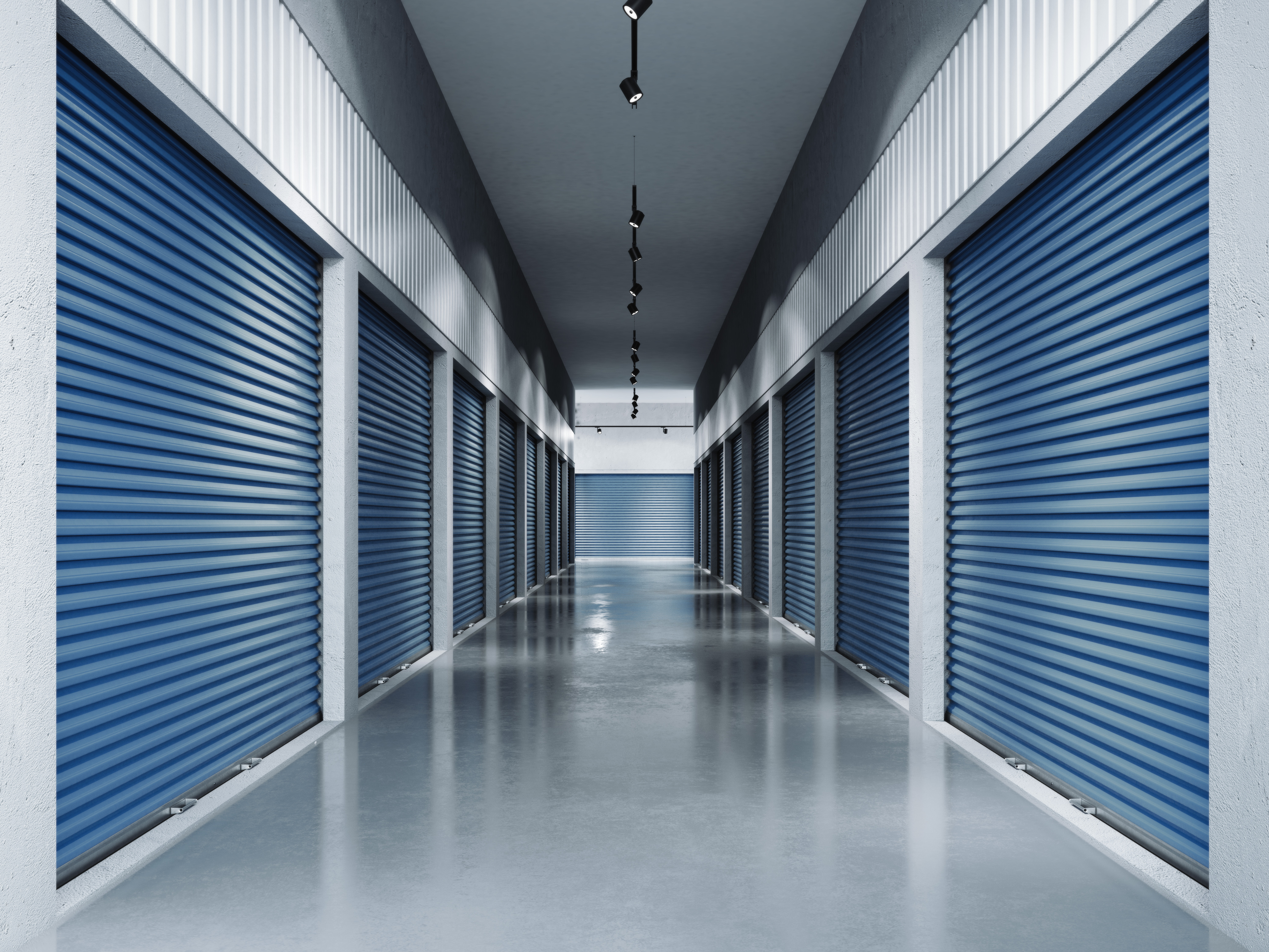 Interior of self storage facility featuring units with blue doors