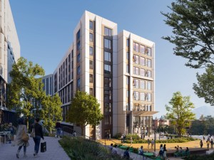 Exterior rendering of one of the buildings within the student housing project. The nine-story building has a white and beige exterior, is surrounded by trees and a lawn.