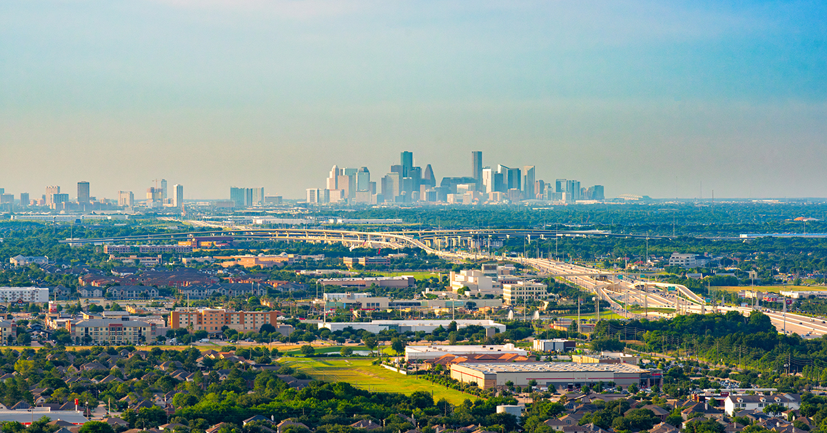 The distant skyline of Houston, Texas shot via helicopter at an altitude of about 1000 feet from about 10 miles south of the city.