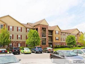 Exterior shot of one of the buildings at 5 Twenty Four and 5 Twenty Five Angliana. The three-story structure has a beige and rock façade.