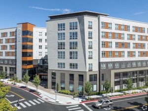 Exterior rendering of HERE Reno, a seven-story building with white, gray and orange façade.