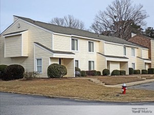Exterior shot of one of the residential buildings within Harbour Landing in Columbia, S.C. The low-rise has two stories and a pale-yellow exterior.