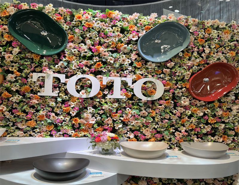 A display of Toto colored sinks against a floral backdrop