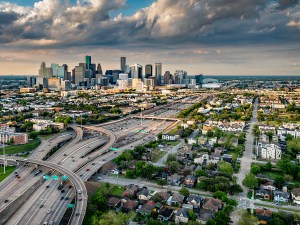 The modern skyline of Houston, Texas as the city lights begin to illuminate at dusk on a summer evening shot via helicopter from an altitude of about 800 feet.