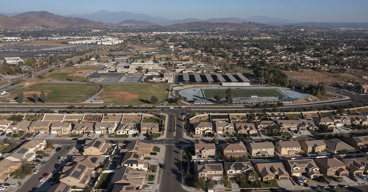 Jurupa Valley, California, USA - November 9, 2024: Afternoon sun shines on newly constructed school and suburban homes.