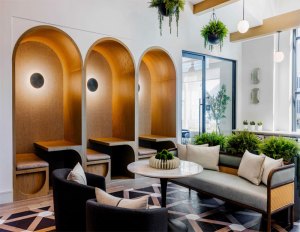 Indoor common area with a couch, chairs and booth seating at At Park & Arbor, a 130-unit community in Old Tappan, N.J.