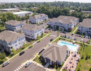 An aerial photograph of Jacksonville Station, an apartment community in Warminster, Pa., with the community swimming pool in the foreground.