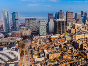 Sunny cityscape of modern Boston, Massachusetts, USA. Footage above old-fashioned orange brick buildings with the view on high-rise downtown.