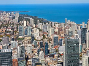 Aerial View of Chicago Skyline with Lake Michigan in Background. Aerial photograph showcasing Chicago's vibrant skyline with dense high-rise buildings, a clear view of Lake Michigan