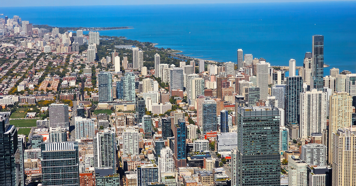 Aerial View of Chicago Skyline with Lake Michigan in Background. Aerial photograph showcasing Chicago's vibrant skyline with dense high-rise buildings, a clear view of Lake Michigan