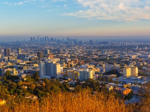Captivating aerial view of downtown Los Angeles at sunset, showcasing the city's skyline, residential areas, and vibrant atmosphere under a colorful sky.