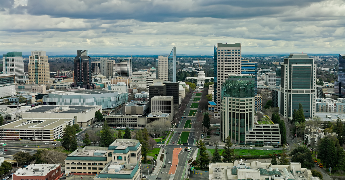 Drone shot of downtown office buildings and the California State Capitol in Sacramento on a cloudy day.
