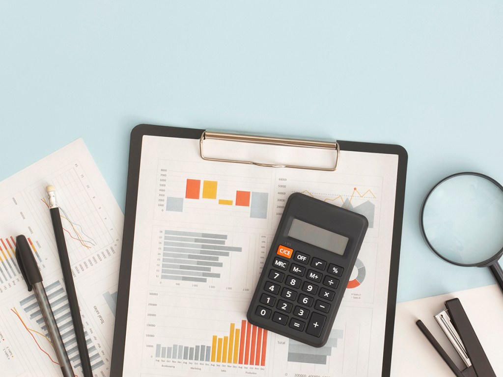 Business graphs, charts, magnifying glass and calculator on table. Financial development, Banking Account, Statistics
