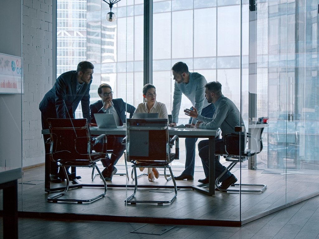 People at a meeting, with only one woman at the table.