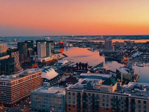 Progression over the City of Baltimore toward the inner harbor while hopping over each building that's constructed below as the focus bounces across the skyline and into the rich colors of the horizon