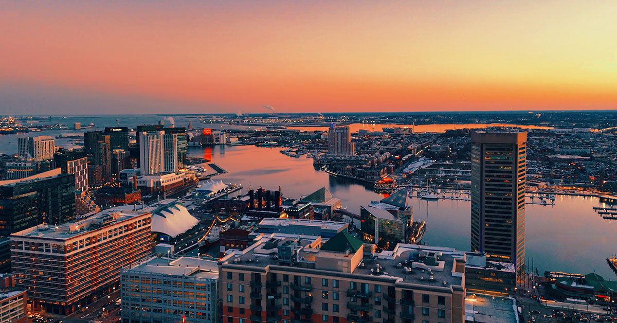 Progression over the City of Baltimore toward the inner harbor while hopping over each building that's constructed below as the focus bounces across the skyline and into the rich colors of the horizon