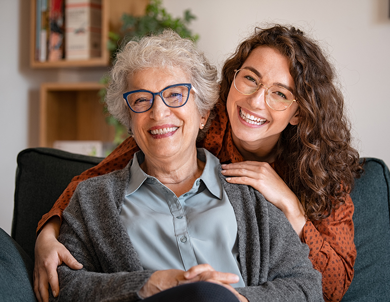 Grandmother and granddaughter sitting on a couch.