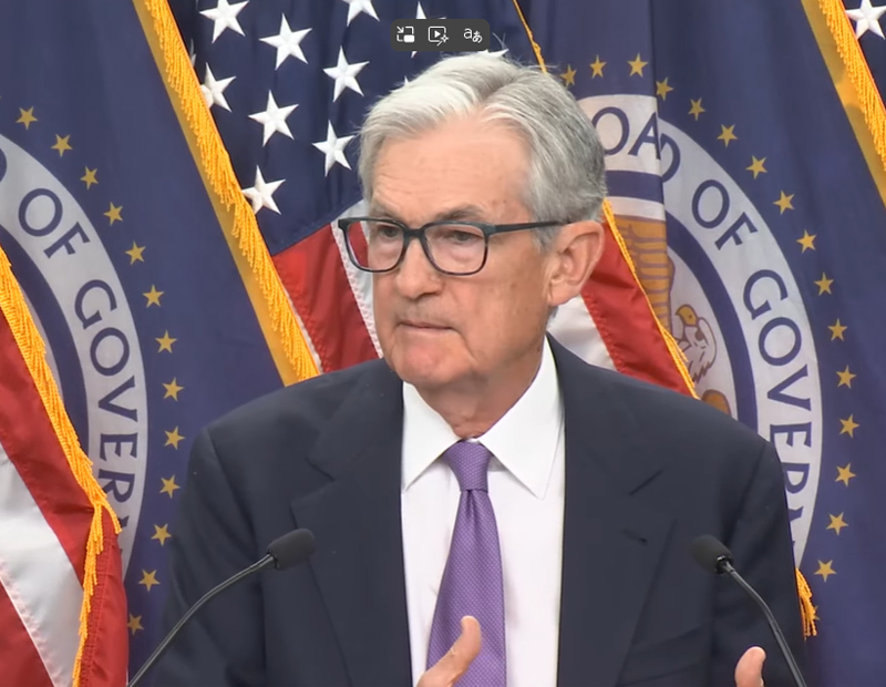 A photo showing Federal Reserve Chair Jerome Powell speaking at a press conference.