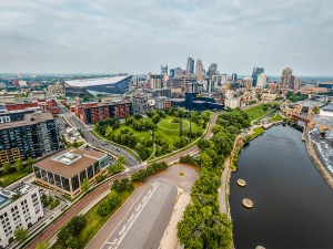 Minneapolis, MN, USA - June 10, 2025: Mississippi River, historic Stone Arch Bridge, US Bank Stadium, and modern skyscrapers