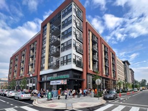 Exterior shot depicting a mixed-use property, with its retail portion anchored by Whole Foods.