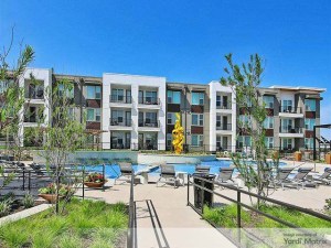 Exterior shot depicting one of the buildings and swimming pools of Birchstone Ceder Ridge, formerly Jefferson Cedar Ridge, a multifamily property in Dallas.
