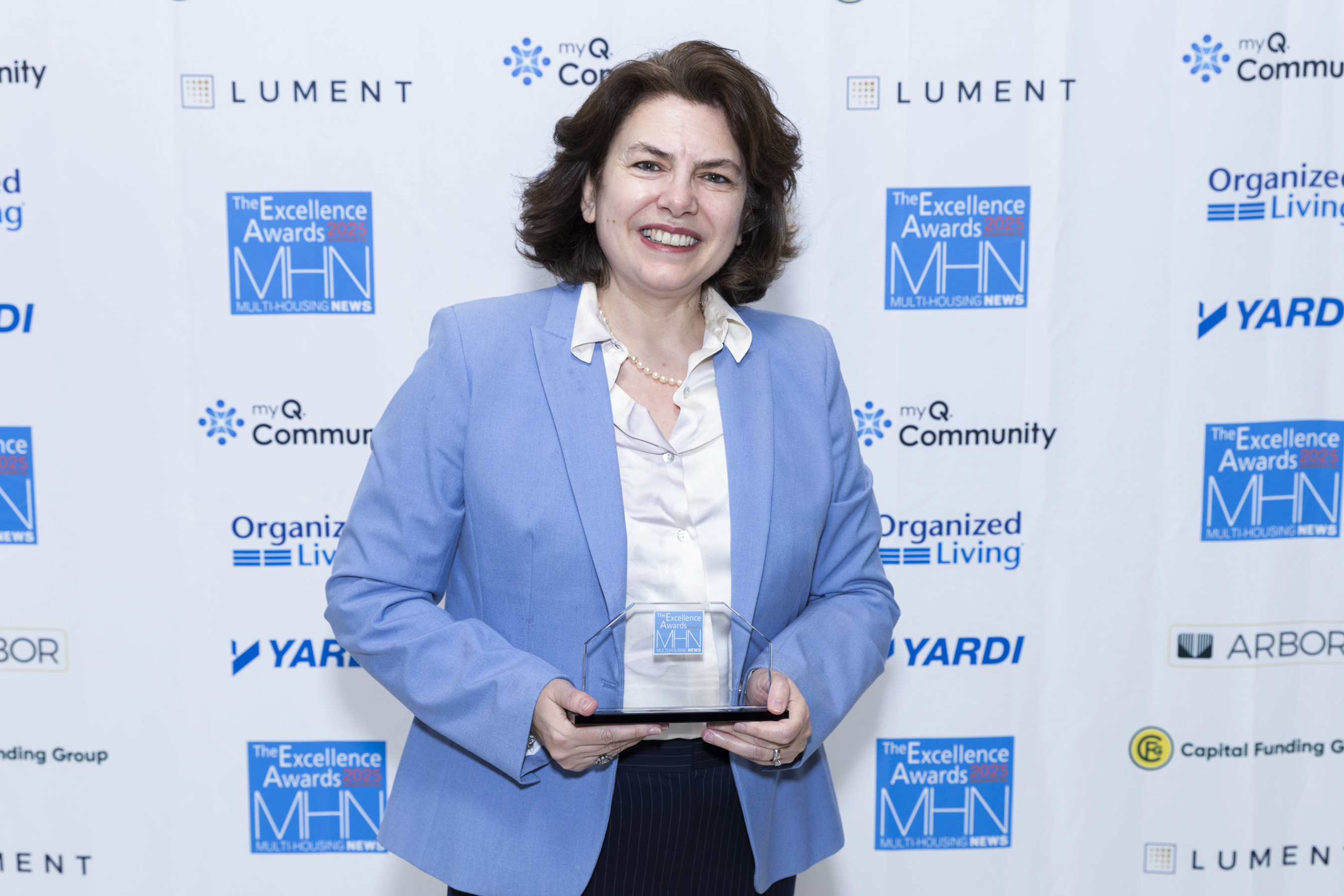 Nesli Dogrusoz accepting for Torti Gallas and Partners. They won Silver for both Best Development & Design: Affordable (The Westerly) and Best Development & Design: High-Rise (101 N. Meridian). Image by Gary Spector