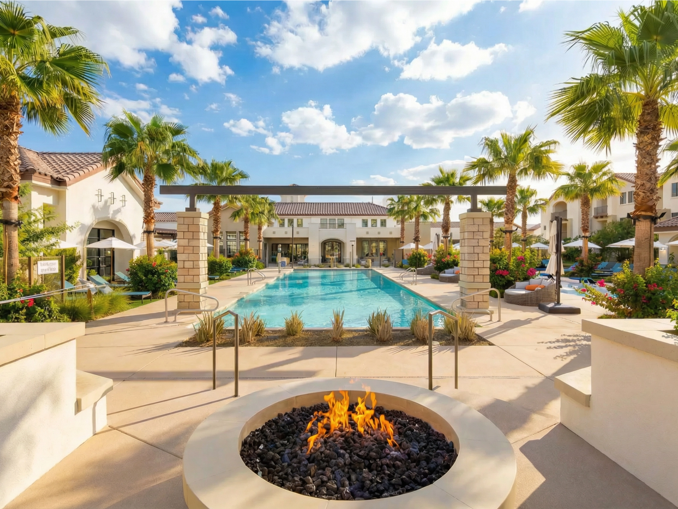 Exterior shot of Spire Deer Valley at 24100 N 19th Ave, containing a swimming pool, fire pit and palm trees with a building in the foreground