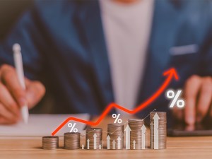 Fundraising businessman depicted alongside increasing monetary returns with a percentage chart going up and to the right.