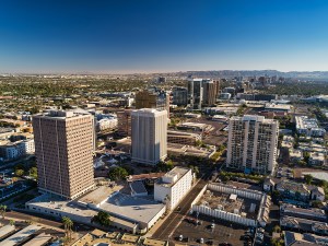 Midtown Phoenix aerial with Downtown Phoenix skyline and South Mountain in the distance.