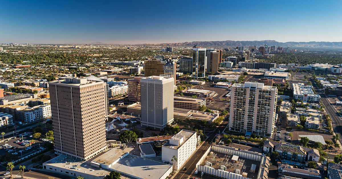 Midtown Phoenix aerial with Downtown Phoenix skyline and South Mountain in the distance.